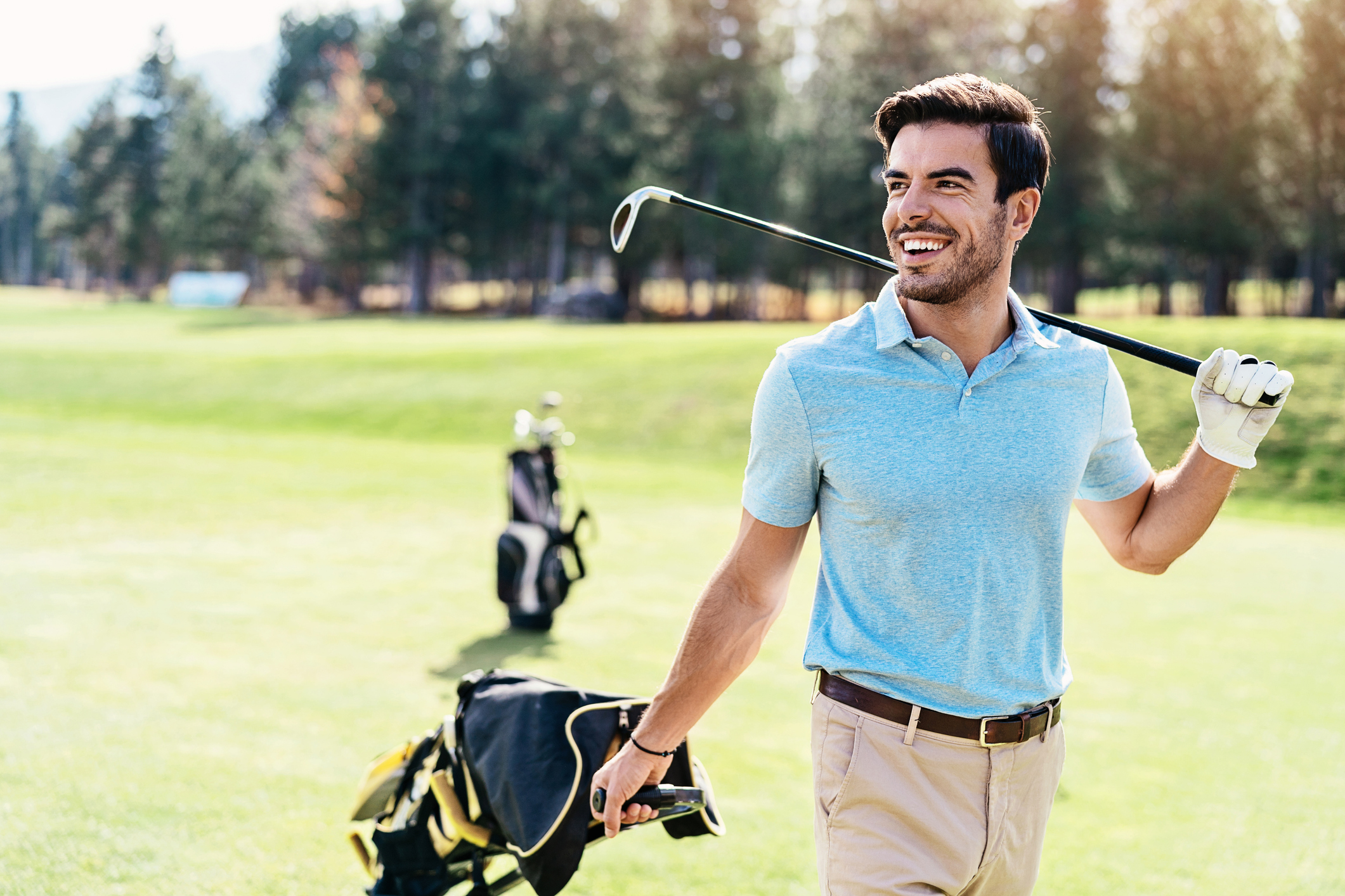 Smiling golf player walking on the course